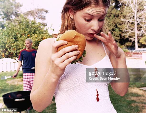 teenage girl (16-18) looking at  ketchup stains on white dress - food stains stock pictures, royalty-free photos & images