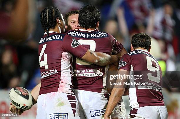 Josh Perry of the Eagles celebrates with his team mates after scoring a try during the round 18 NRL match between the Manly Warringah Sea Eagles and...