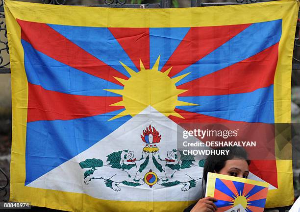 An exiled Tibetan student living in India holds a Tibetan flag in honour of spiritual leader Dalai Lama, in observance of his 74th birthday in...