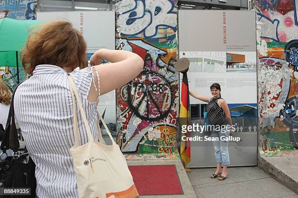 Tourist from Lithuania is photographed by a friend at a memorial to the former Berlin Wall that contains original pieces of the wall at Postdamer...