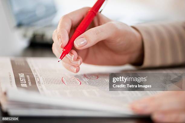 woman circling classfields, close-up - desemprego imagens e fotografias de stock