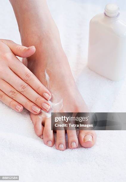 close-up of woman moisturizing foot - human foot stock pictures, royalty-free photos & images