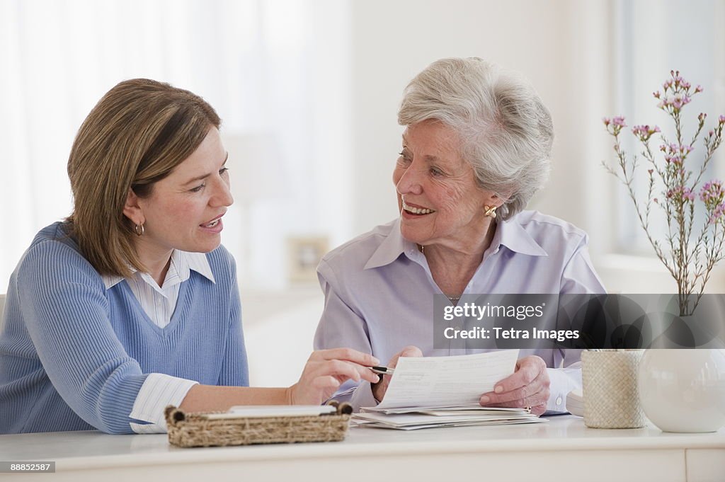 Daughter helping her mother paying bills