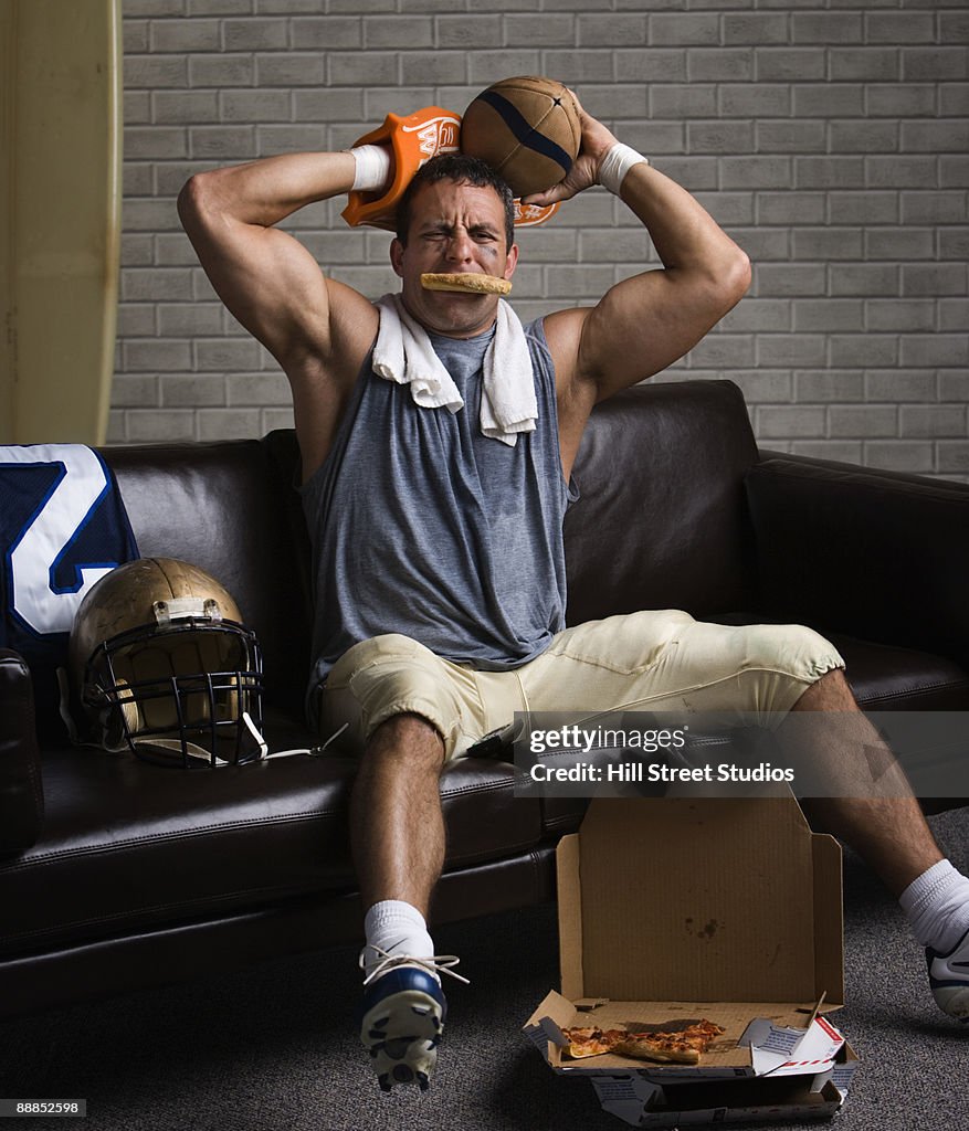 Football player with pizza in mouth looking frustrated