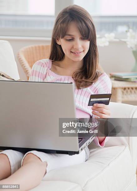 preteen girl (10-11 years) doing online shopping and holding credit card - 10 11 years ストックフォトと画像