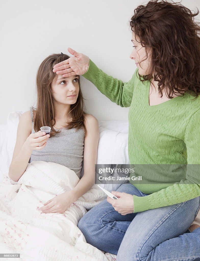 Mother measuring daughters (10-11 years) fever