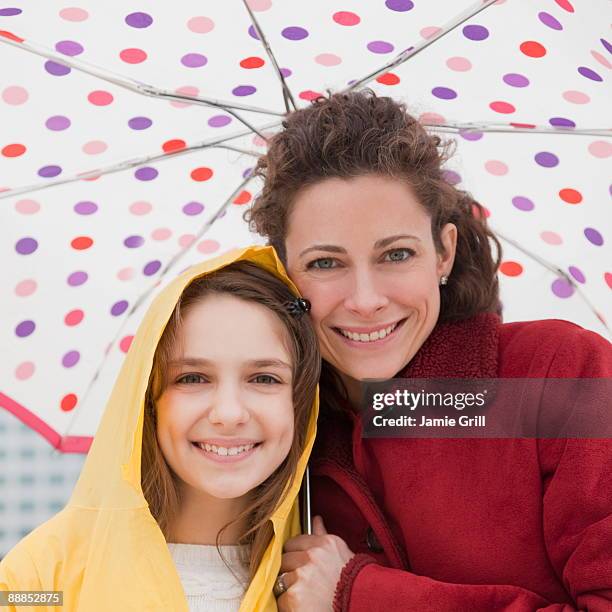 mother and daughter (10-11 years) under umbrella, portrait - 30 34 years foto e immagini stock
