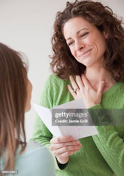 mother receiving greeting card on mothers day from daughter (10-11 years) - receiving card stock pictures, royalty-free photos & images