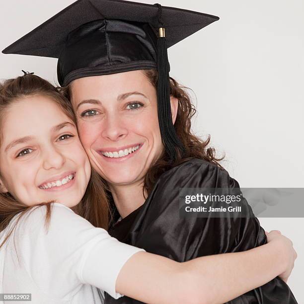 daughter (10-11 years) embracing mother after her graduation, smiling, portrait - 30 34 years bildbanksfoton och bilder