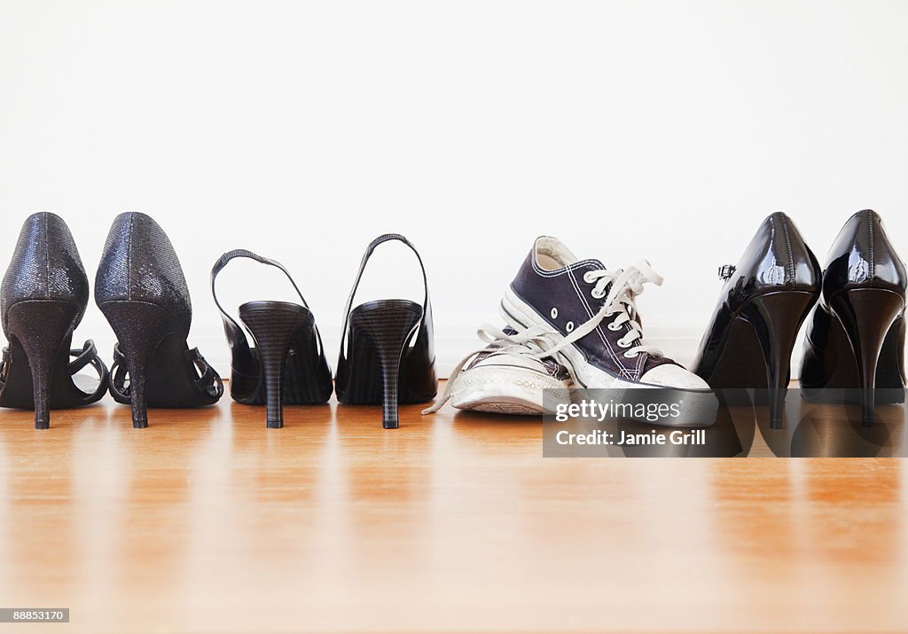 Canvas shoe in row of elegant high heel shoes
