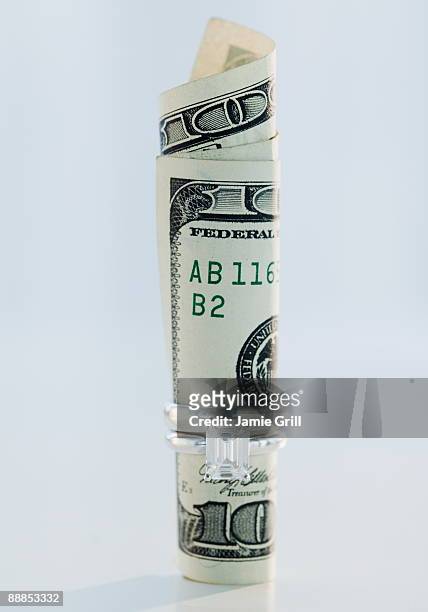 one hundred dollar bill rolled up in wedding ring - married money stock pictures, royalty-free photos & images
