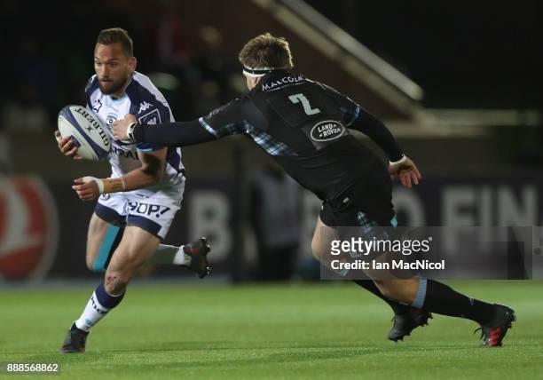 Aaron Cruden of Montpellier is tackled by George Turner of Glasgow Warriors during the European Rugby Champions Cup match between Glasgow Warriors...