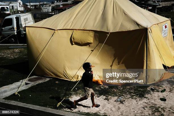 Child walks by a tent on the nearly destroyed island of Barbuda on December 8, 2017 in Cordington, Barbuda. Barbuda, which covers only 62 square...
