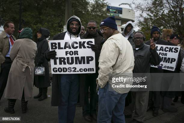 Attendees hold "Blacks For Trump" signs while waiting in line for a campaign rally with U.S. President Donald Trump in Pensacola, Florida, U.S., on...