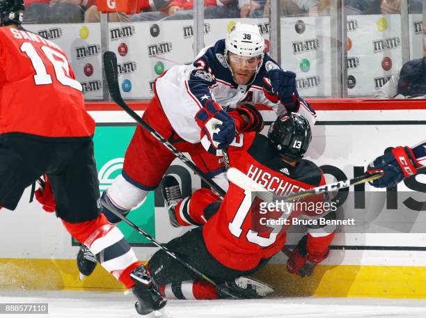 Boone Jenner of the Columbus Blue Jackets checks Nico Hischier of the New Jersey Devils during the first period at the Prudential Center on December...