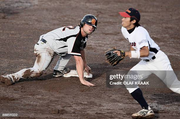 Dutch Mark-Jan Moorman and Yohei Yamato of Japan look for the ball during the World Port Honkbal Tournament 2009 in Rotterdam, on July 06, 2009. The...