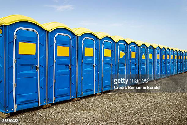 row of portable toilets - mietklo stock-fotos und bilder
