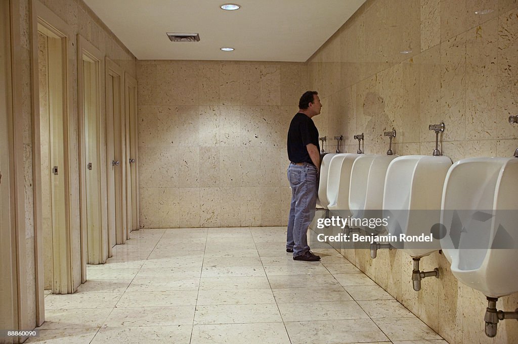 Using Urinal Man Using Urinal In Public Bathroom High-Res Stock Photo - Getty Images