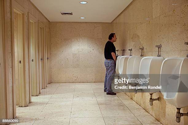 man using urinal in public bathroom - people peeing 個照片及圖片檔