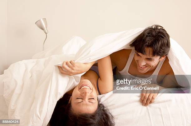 couple laughing in bed together - couple on bed stockfoto's en -beelden