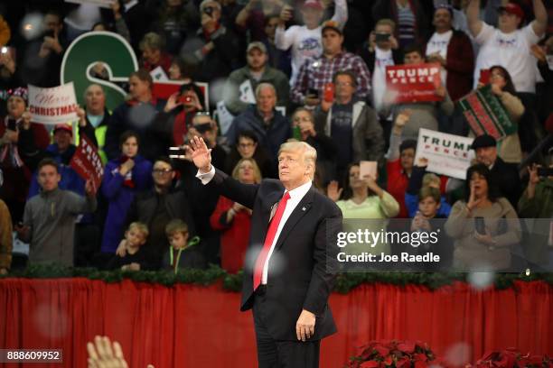 President Donald Trump waves as fake snow falls as he ends a rally at the Pensacola Bay Center on December 8, 2017 in Pensacola, Florida. Mr. Trump...