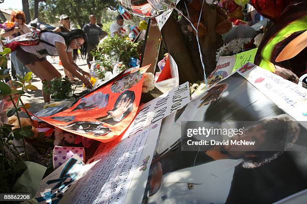 Fans pay their respects at a makeshift memorial outside the Jackson family home as Los Angeles prepares for memorial services for singer Michael...