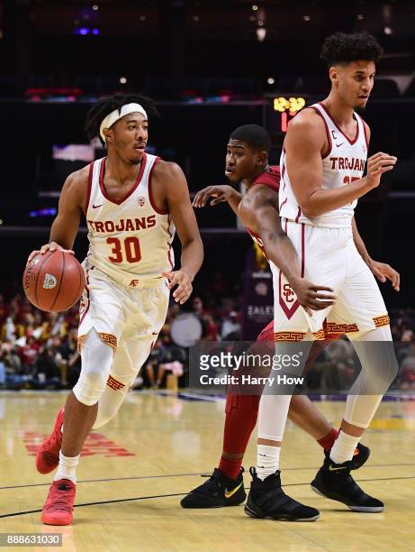 Elijah Stewart of the USC Trojans uses a screen from Bennie Boatwright on Christian James of the Oklahoma Sooners during the Basketball Hall of Fame...