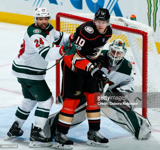 Corey Perry of the Anaheim Ducks battles in front of the net against Matt Dumba and Devan Dubnyk of the Minnesota Wild during the game on December 8,...
