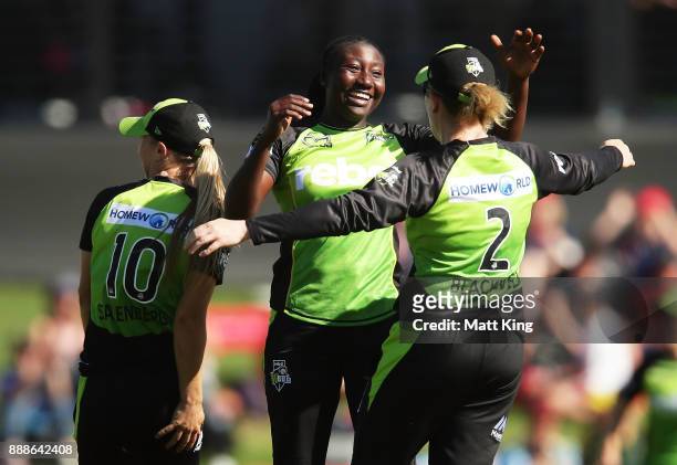 Stafanie Taylor of the Thunder celebrates victory with Naomi Stalenberg and Alex Blackwell during the Women's Big Bash League WBBL match between the...