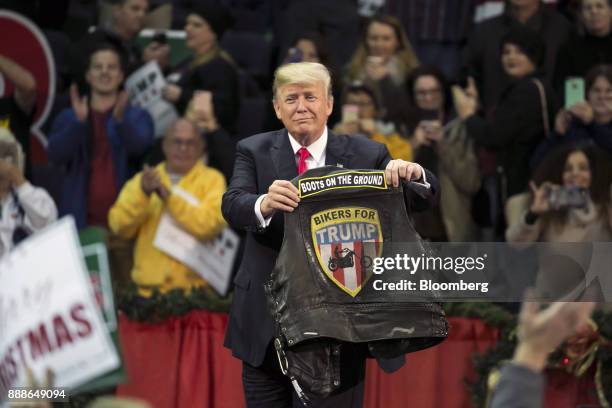 President Donald Trump holds a vest reading "Bikers For Trump" during a rally in Pensacola, Florida, U.S., on Friday, Dec. 8, 2017. Trump gave his...