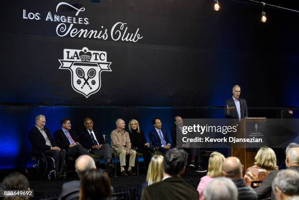 Todd Martin, CEO of International Tennis Hall of Fame, speaks during a ceremony to honor Alex Olmedo with his ITHF ring with hall of Famer, seated...