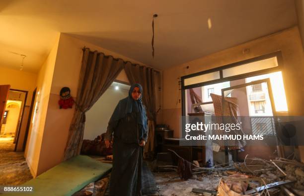 Palestinian woman inspects the damage at her house on December 9 in the aftermath of an Israeli air strike in Beit Lahia, in the northern Gaza Strip....