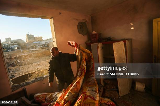 Palestinian man inspects the damage at his house on December 9 in the aftermath of an Israeli air strike in Beit Lahia, in the northern Gaza Strip....