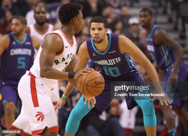 Michael Carter-Williams of the Charlotte Hornets defends against Kyle Lowry of the Toronto Raptors during NBA game action at Air Canada Centre on...