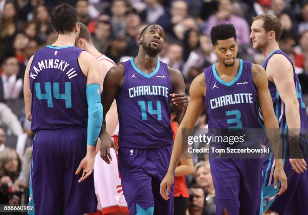 Michael Kidd-Gilchrist of the Charlotte Hornets looks up at the scoreboard as Frank Kaminsky III and Jeremy Lamb and Cody Zeller look on against the...