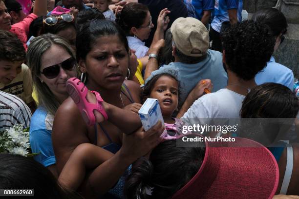 Child is carried in his arms by a woman amid the crowd of feis, in the city of Recife, in the Northeast of Brazil, on December 8, 2017. Thousands of...