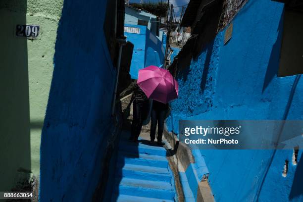 Two women are seen sheltering from the sun and descending a staircase used by devotees of the Immaculate Conception to pay for penance during the...