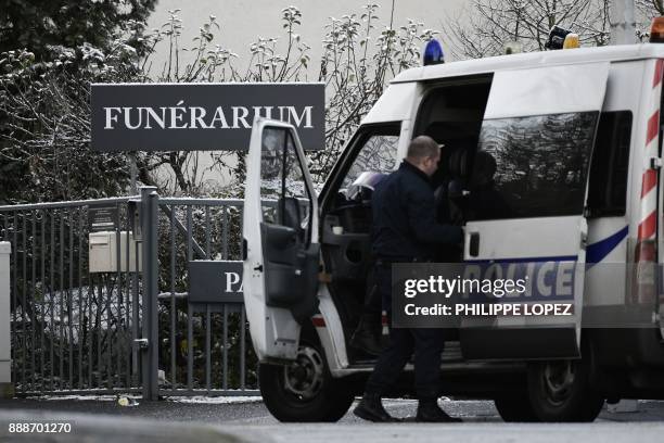 French police officers wait in front of the Mont-Valerien funeral home prior to the departure of the funeral cortege during a 'popular homage' to...