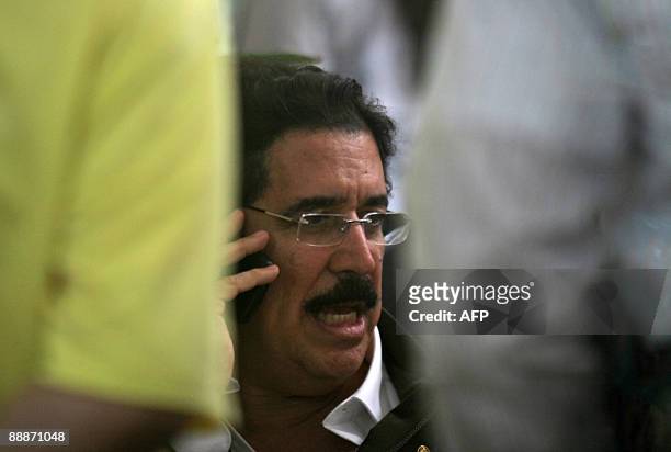 Honduras' ousted President Manuel Zelaya speaks on a mobile phone at a shopping mall in Managua, on July 6, 2009. Honduran coup leaders faced further...