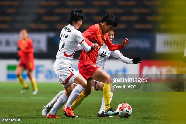 Wang Shanshan of China is challenged by Ri Hyang Sim and Kim Nam Hui of North Korea during the EAFF E-1 Women's Football Championship between China...
