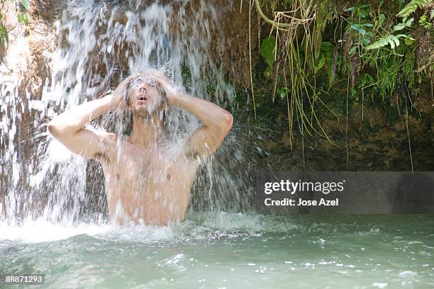 a young man stands under the cascades of agua azul - agua azul stock-fotos und bilder