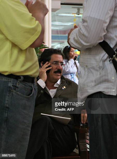 Honduras' ousted President Manuel Zelaya speaks on a mobile phone at a shopping mall in Managua, on July 6, 2009. Honduran coup leaders faced further...