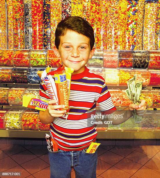 young boy (6-8) in candy store with chocolate and money (composite) - like a child in a sweet shop stock pictures, royalty-free photos & images