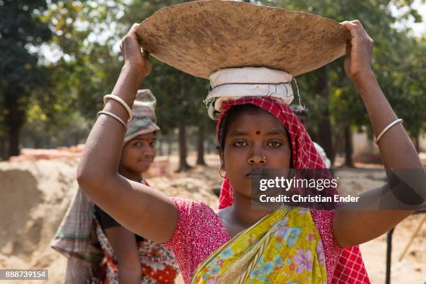 Jibanpur, India A woman is transporting sand in a bowl on her head on a construction site in Jibanpur.