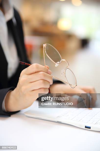 businesswoman using laptop in cafe with eyeglasses - astigmatism stock pictures, royalty-free photos & images