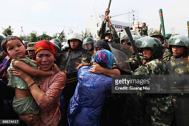 Chinese policemen push Uighur women who are protesting at a street on July 7, 2009 in Urumqi, the capital of Xinjiang Uighur autonomous region,...
