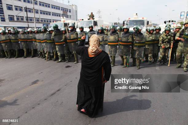 An Uighur woman protests in front of policemen at a street on July 7, 2009 in Urumqi, the capital of Xinjiang Uighur autonomous region, China....