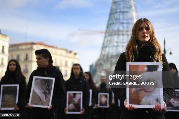 Activists of pro-animal rights group "Igualdad Animal" hold pictures of mistreated animals during a protest marking International Animal Rights Day...