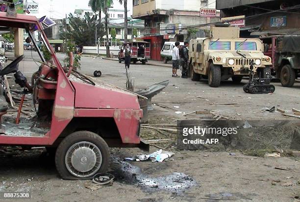 Humvee is parked next to their bomb disposal robot near the bomb blast site at a commercial center in Jolo, on the island of Mindanao on July 7,...