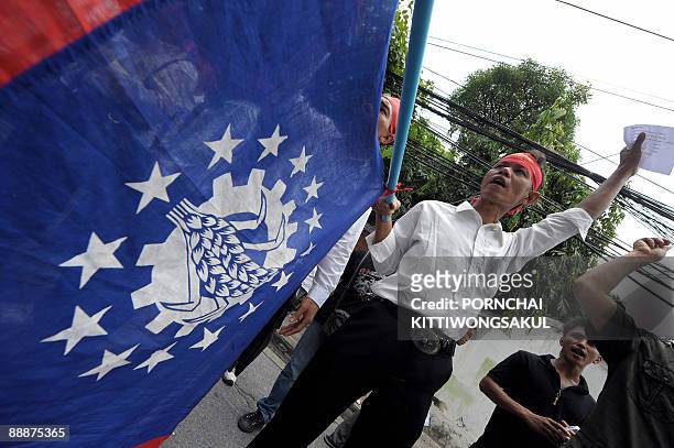 Myanmar activists shout slogans while wave national flags during a demonstration at the Myanmar embassy in Bangkok on July 7, 2009. The activists...